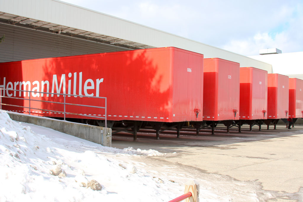 Image showing a row of Herman Miller semi-truck trailers at a loading dock.